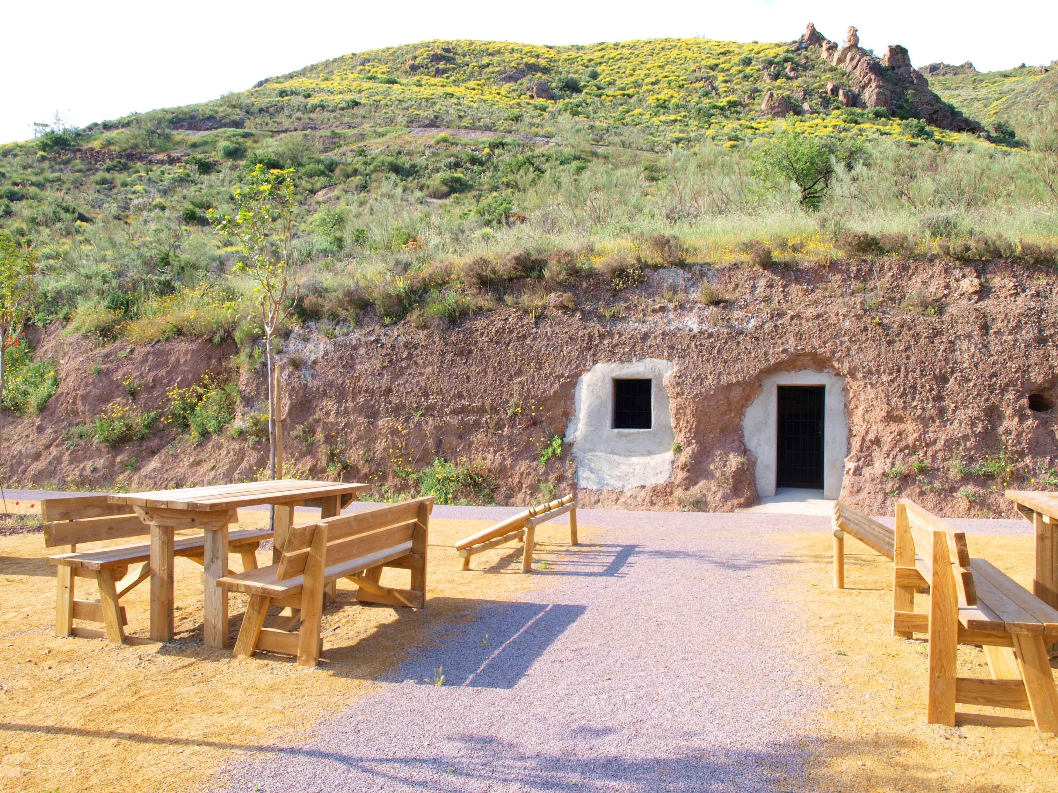 Zona de descanso con asientos y antiguas casas cueva, a mitad aproximadamente del recorrido de la Vía Verde de Lucainena 