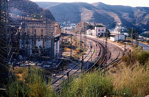 Muy ferroviaria estación de Santa Fe – Alhama, en curva entre un túnel y un viaducto. A la izquierda, nueva y antigua estaciones transformadoras. Entre esta estación y la de Gérgal funcionaron los primeros tractores eléctricos de España en 1911.